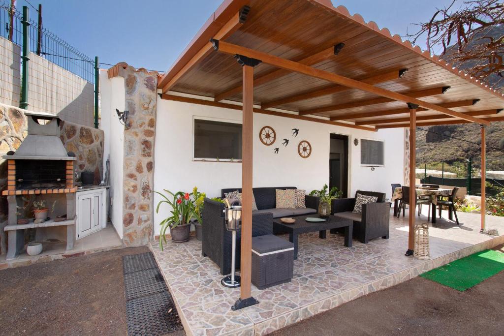 a pavilion with a table and chairs and a fireplace at Vv Tasartico in San Nicolás