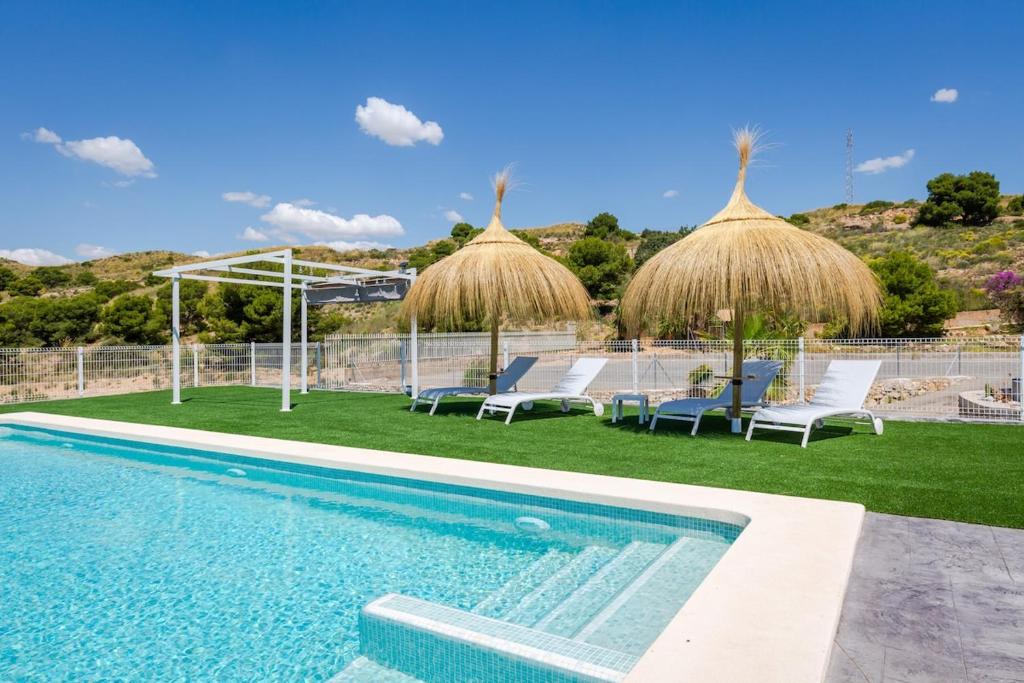a swimming pool with chairs and umbrellas next to at Fidalsa Imperial Malibu in Elche