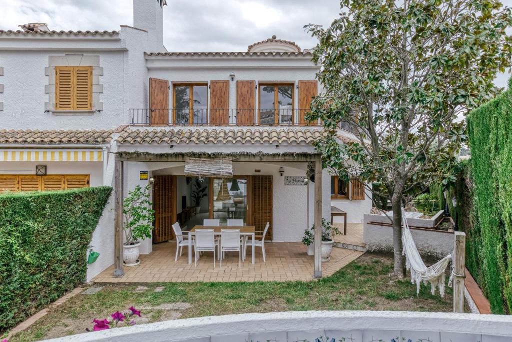 a white house with a table and chairs at Villa la Barrufa in S'agaro