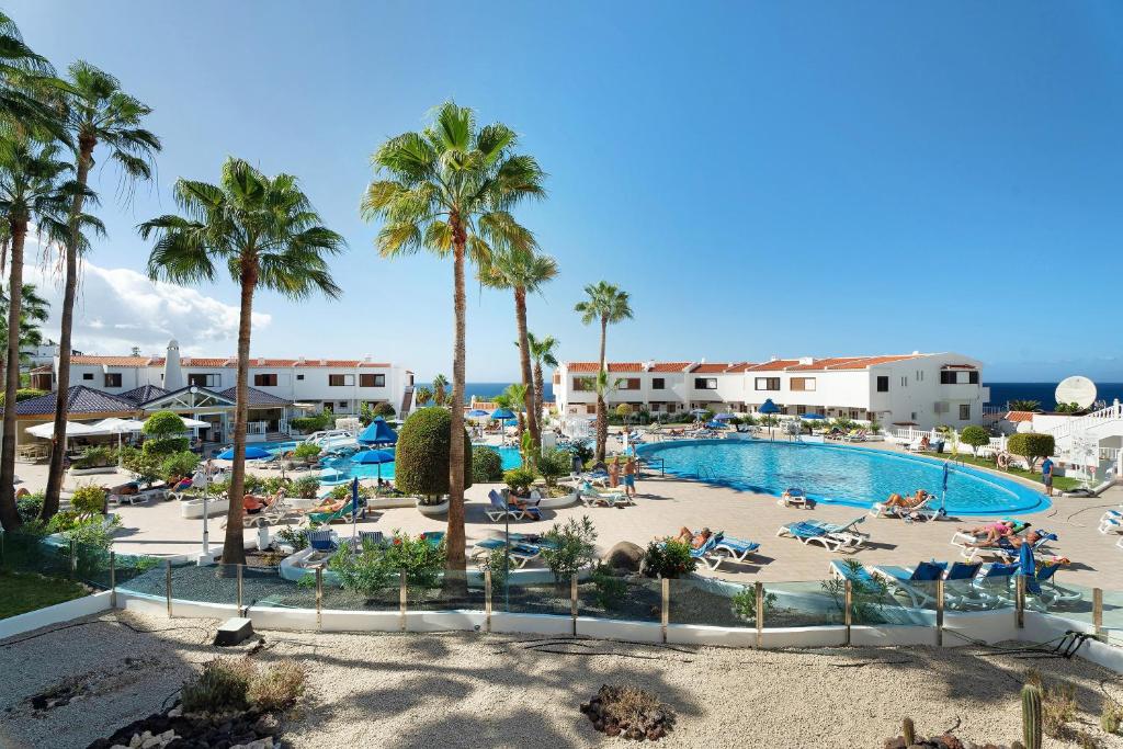 an aerial view of a resort pool with palm trees at Club Atlantis with views in Adeje
