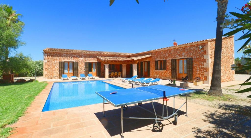 a villa with a ping pong table in front of a pool at Can Mates Nou in Campos