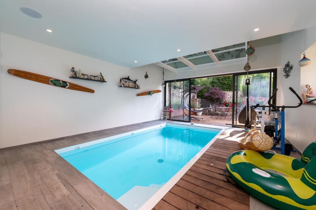 a large swimming pool in a room with a large window at Chambre - Spa - Piscine - Sauna in Brech