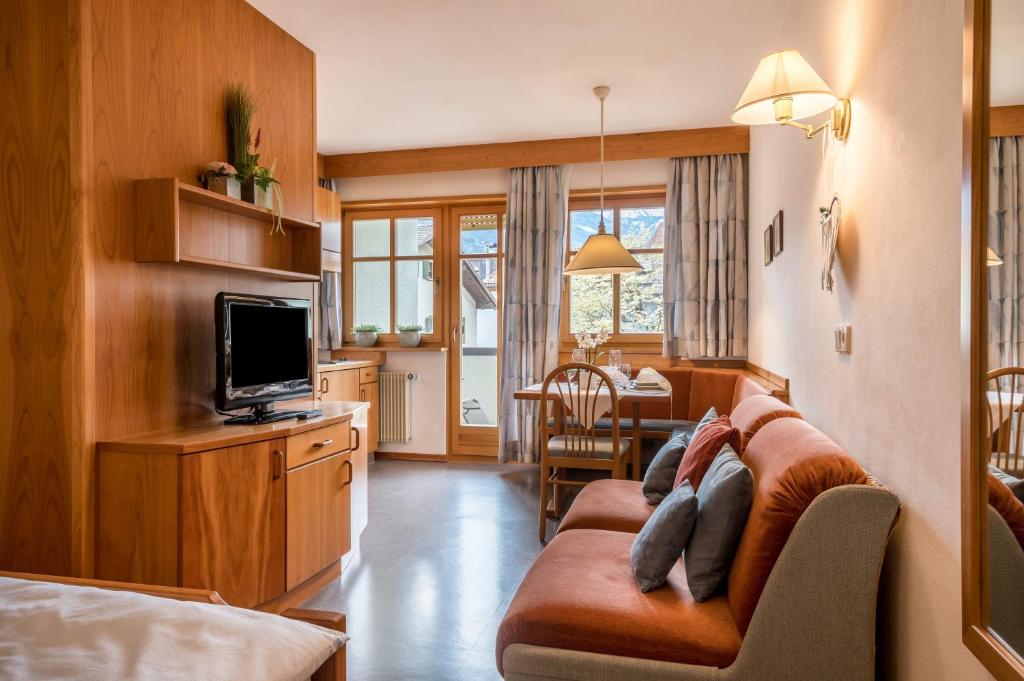 a living room with a couch and a tv at Taufner Apartement A 105 in Parcines