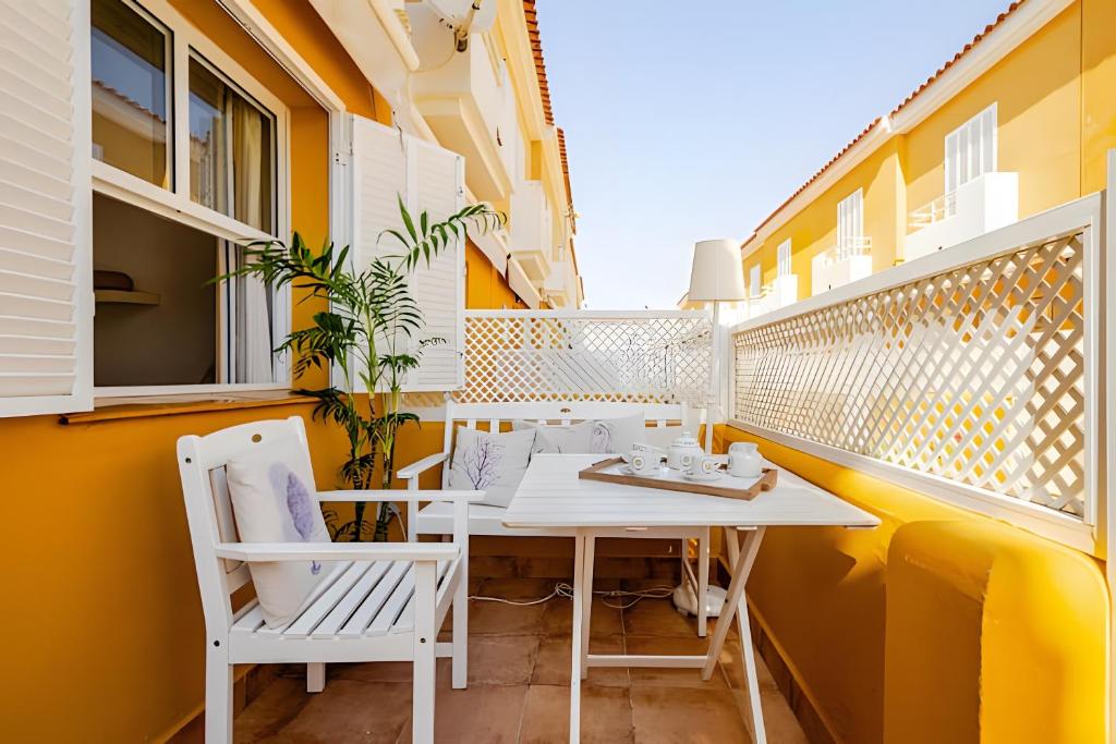 a small balcony with a white table and chairs at 1 Linea Playa , 3 Dorm Islantilla in Isla Cristina