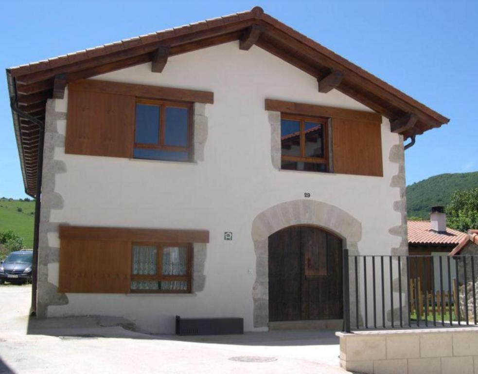 a white house with wooden doors and a gate at Bordaberri in Ciáurriz
