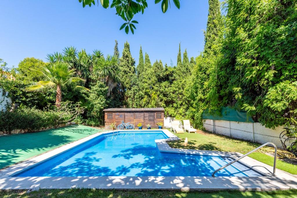 a swimming pool in a yard with trees at Villa La bicicleta azul in Málaga