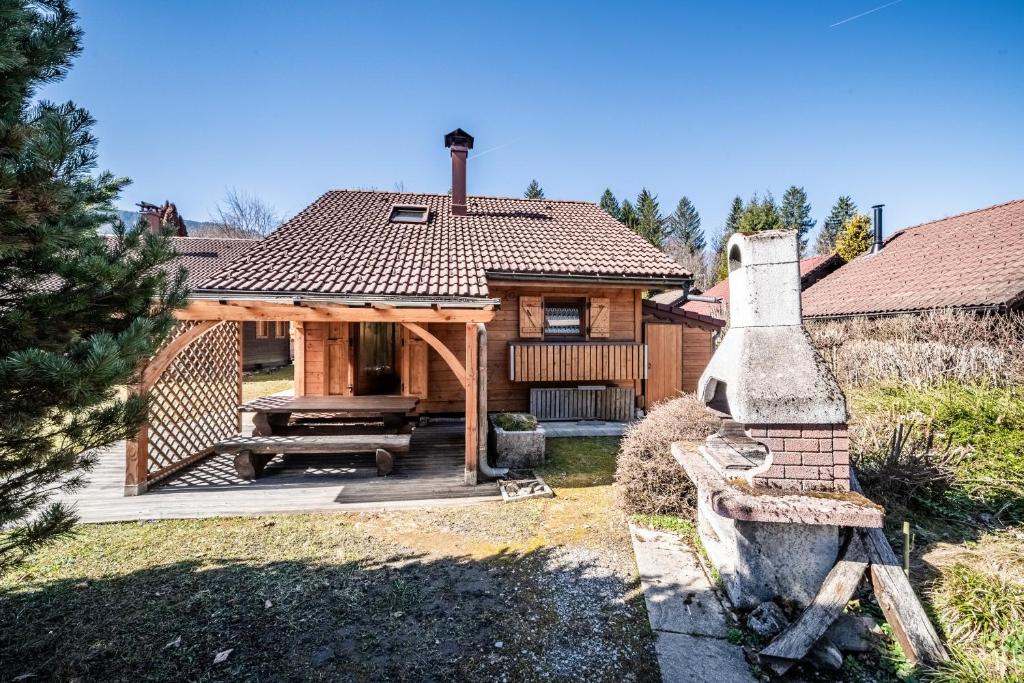 a log cabin with a porch and a bench at Chalet 6p Classique - L'Erable in Verchaix