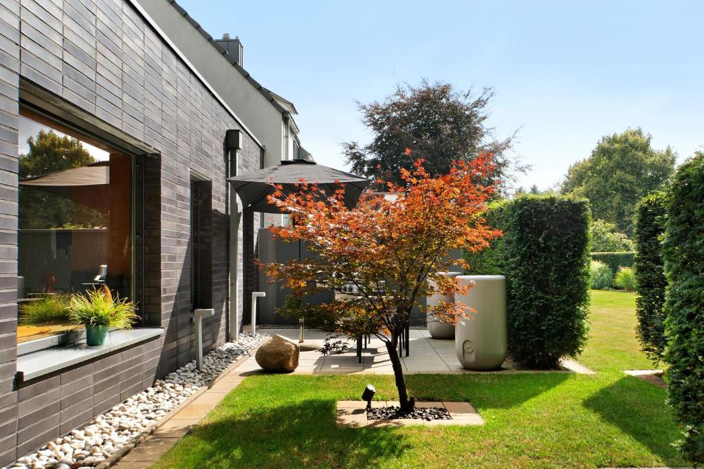 a tree in a yard next to a house at Schicke neue Ferienwohnung, Meppen in Meppen