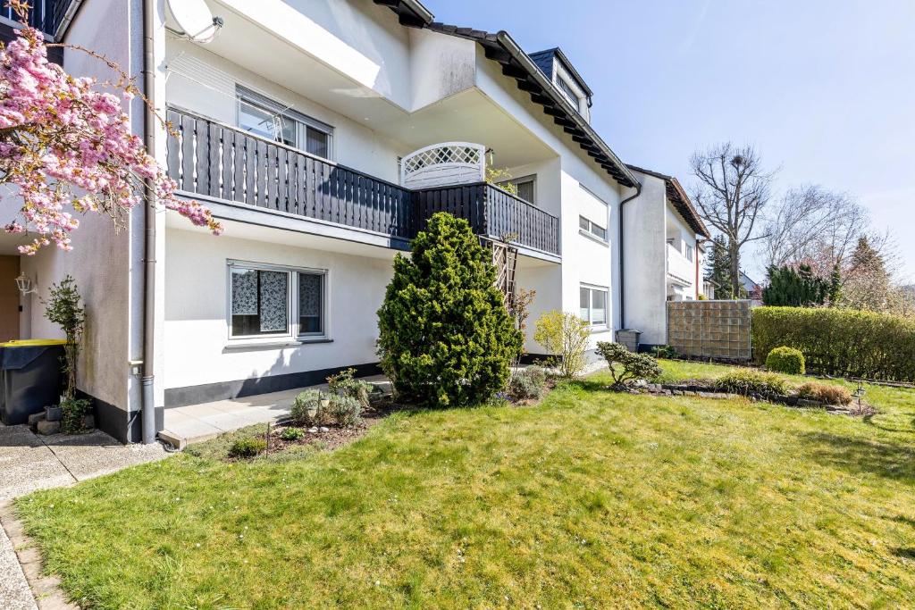 a white house with a lawn in front of it at Ferienwohnung Sterl 13 in Herscheid