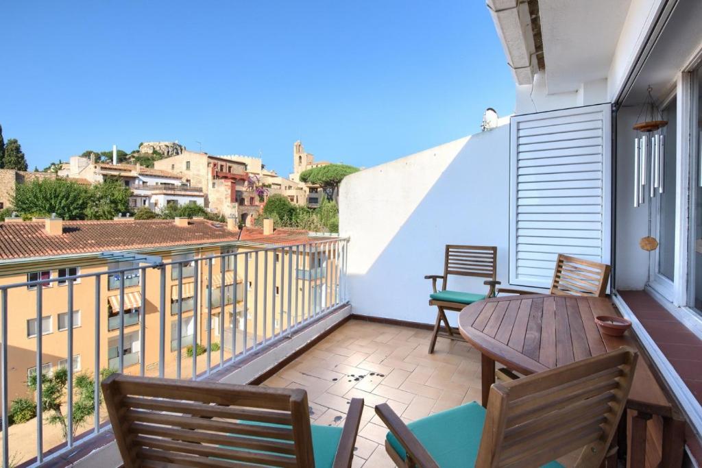 a balcony with a wooden table and chairs and a view at Can Quintaneta in Begur