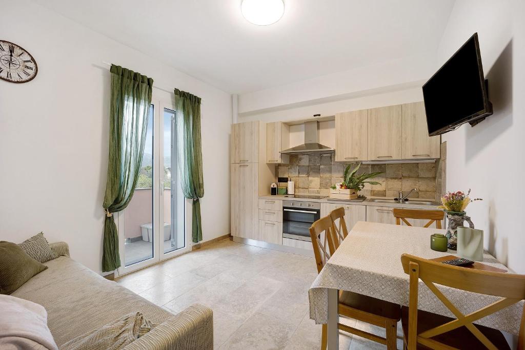 a living room with a table and a kitchen at Antichi Ricordi - Da Angela in Marina di Andora