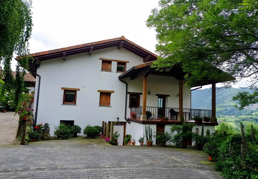 a large white house with a balcony at Lokate 2 Habitaciones in Aia