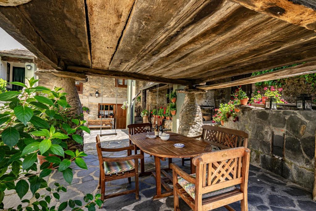 an outdoor patio with a wooden table and chairs at Casa Rural Casa Mario in Cangas del Narcea