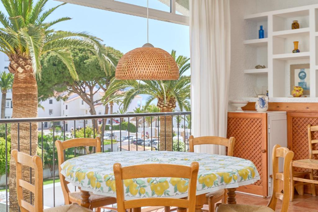 a dining room with a table and a balcony with palm trees at Carabeo 19 in Nerja