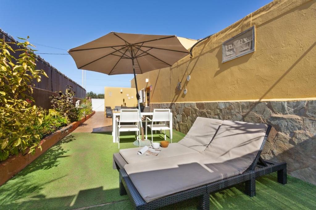 a patio with an umbrella and a table and chairs at Apt Rural Zona Céntrica Isla in Puerto del Rosario