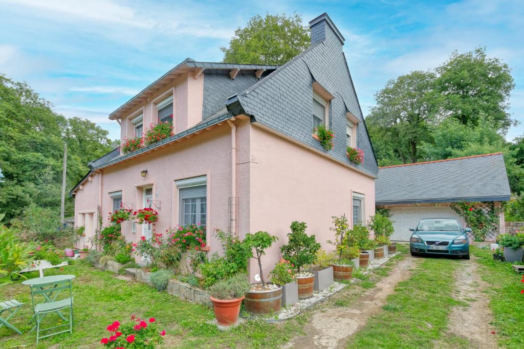 a pink house with a car parked in the yard at La Renardière - Chambre in Férel