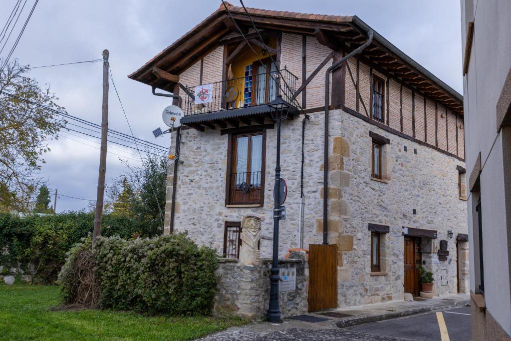 a stone house with a balcony on a street at Zadorra Etxea Casa in Salvatierra