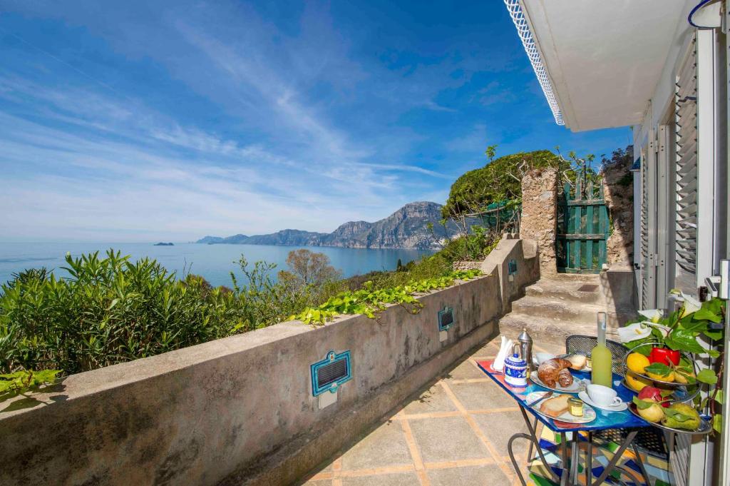 a table with food on it next to the ocean at Casa Il Geco Praiano in Praiano