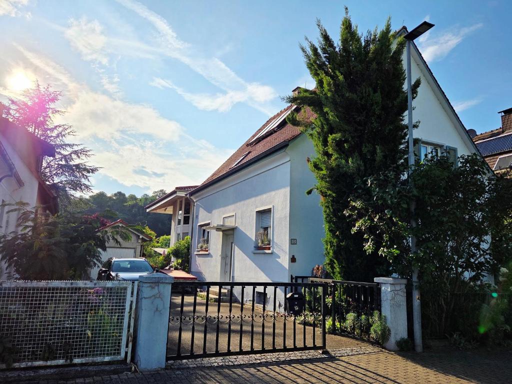 a white house with a fence and a tree at s'Krumme Gustels Hüs in Bahlingen
