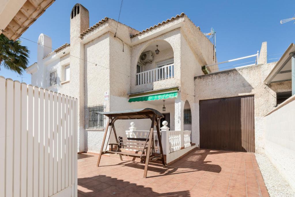 a swing in front of a house with a fence at Hygee in San Javier
