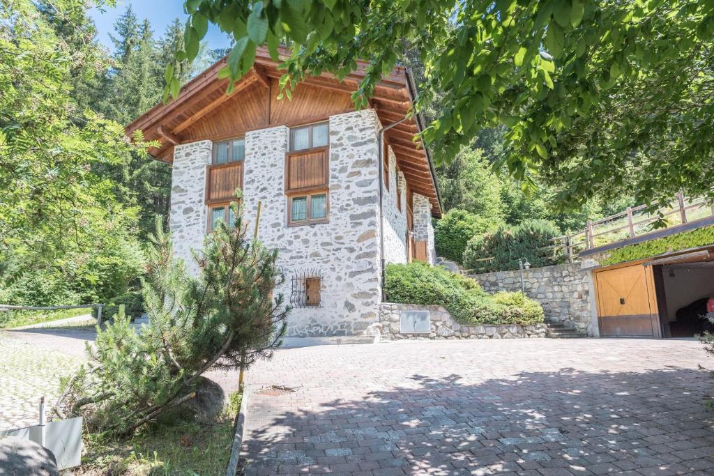 a stone house with a wooden roof at Maso Noce Ovest in Mezzana