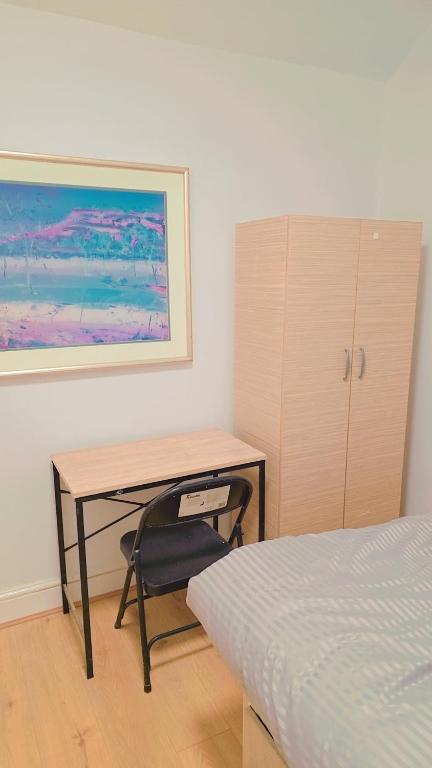 a bedroom with a desk and a bed at Windsor Room in Slough