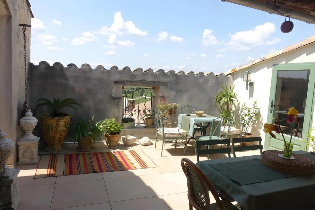 a patio with a table and chairs and a wall at Chambres D'hôtes La Buissonnière in Théziers
