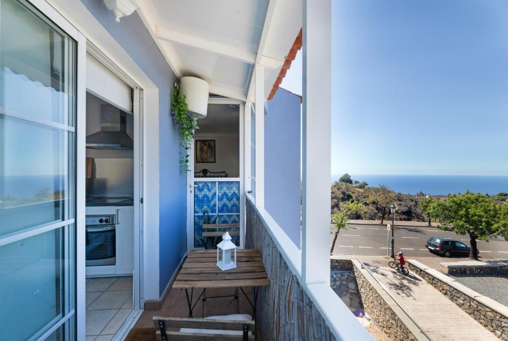 a balcony with a bench and a view of the ocean at El Almendro in Puntagorda