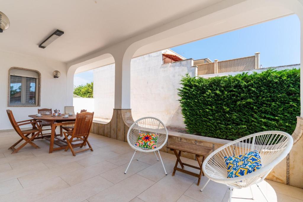 a patio with a wooden table and chairs and a table and chairsktop at Di Chiara in Torre Lapillo
