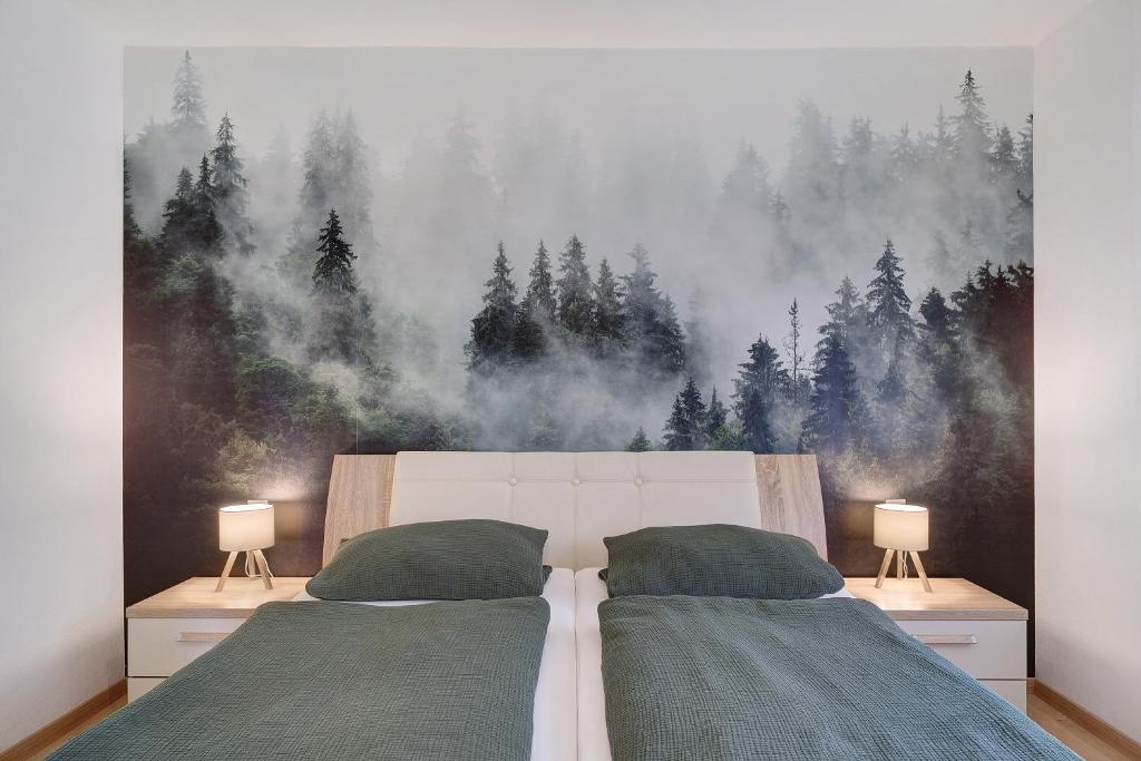 a bedroom with two beds and a forest mural at Schwarzwald-Kitz mit Pool und Sauna in Lenzkirch