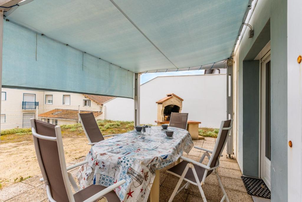 a patio with a table and chairs on a balcony at Entre plage, forêt et villages in Mimizan