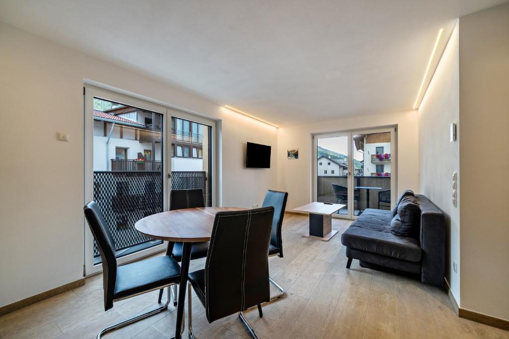 a living room with a table and chairs and a couch at Ferienwohnung Lamm 2 in San Valentino alla Muta