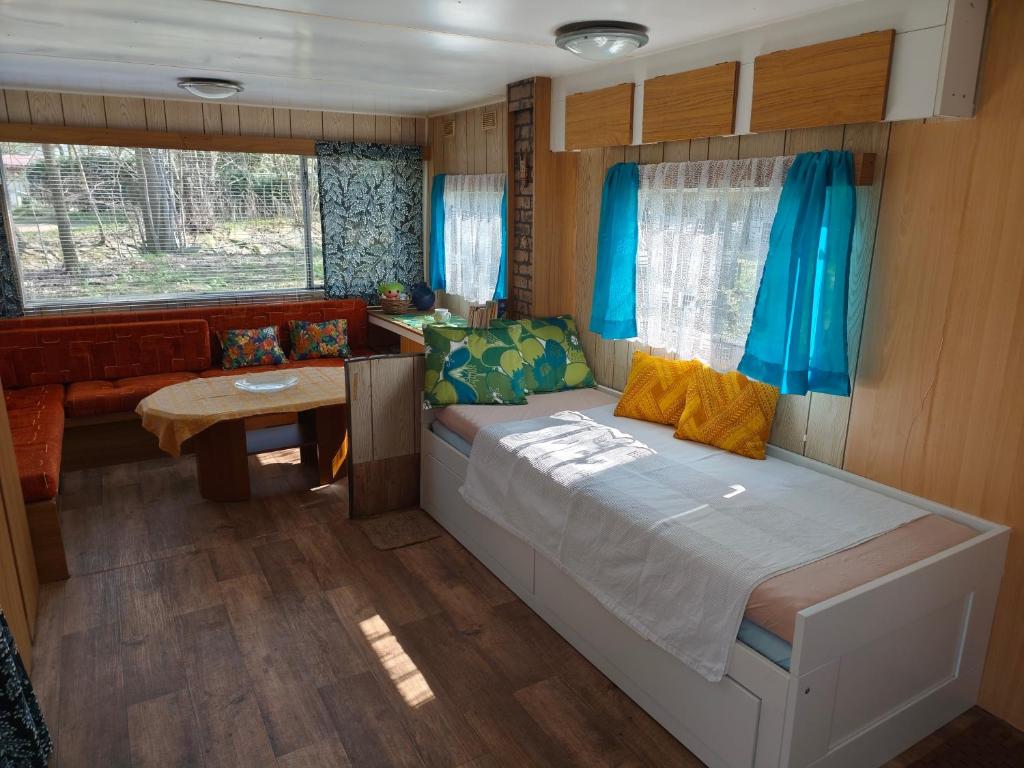 a small bedroom with a bed and a table at Horyna - Camp Pod kastany in Morávka