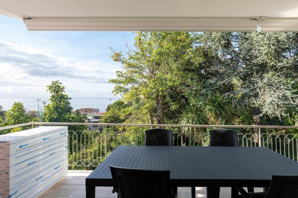 a table and chairs on a balcony with a view at Casa Alizia in Ospedaletti