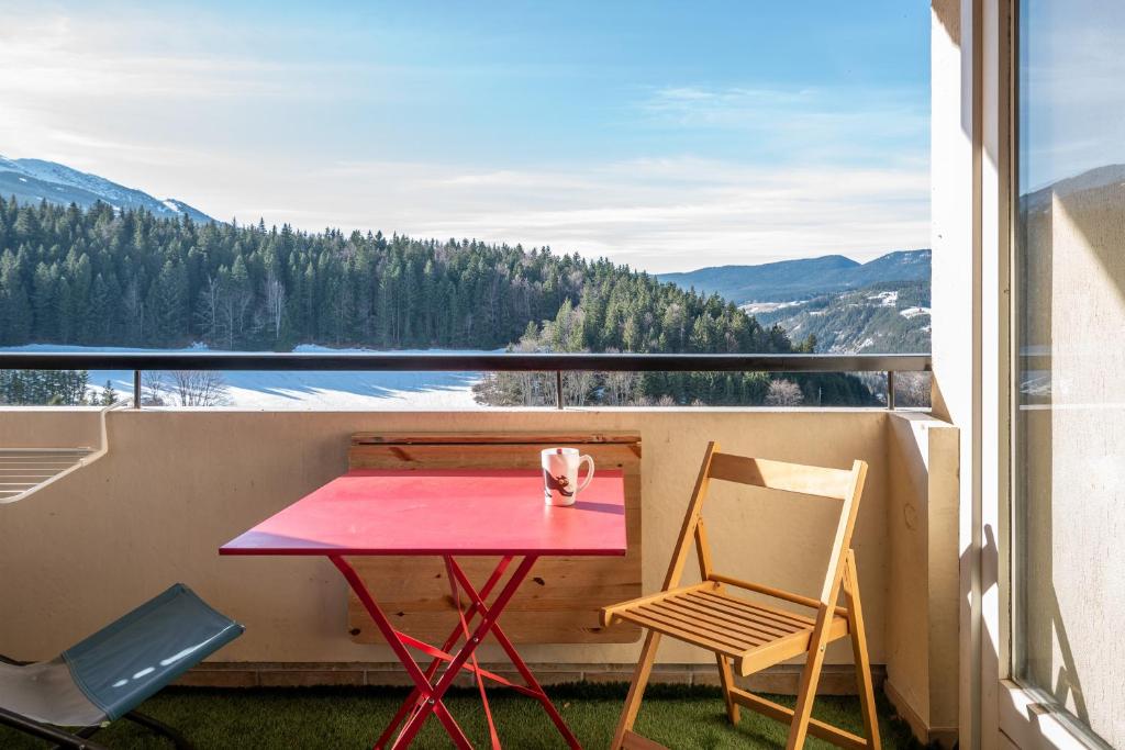 a table and two chairs on a balcony with a view at Métamorphose Au Sommet in Villard-de-Lans