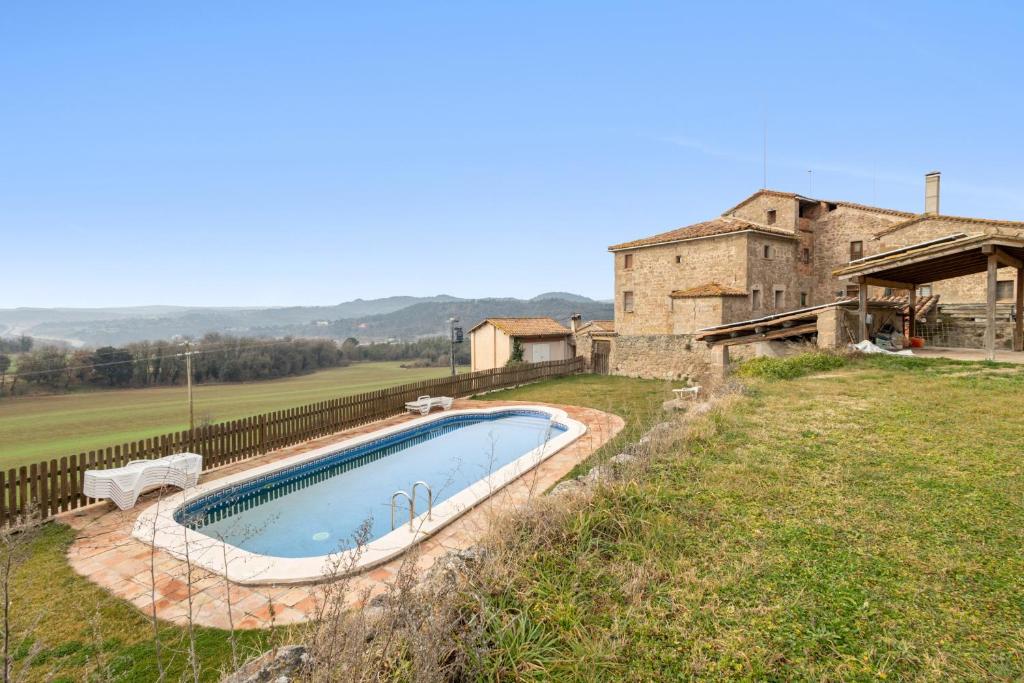 a swimming pool in a field next to a building at Volta De Ferreres in Olvan