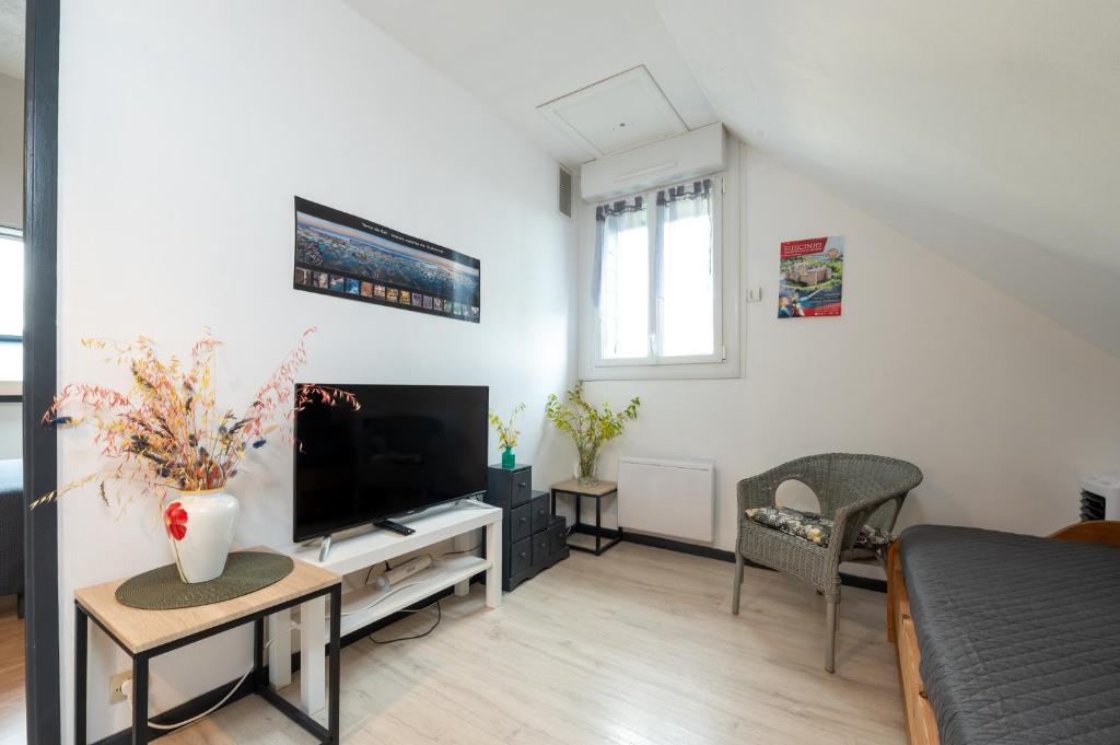 a living room with a television and a couch at Logement Rieux À 6 Km De Redon in Rieux