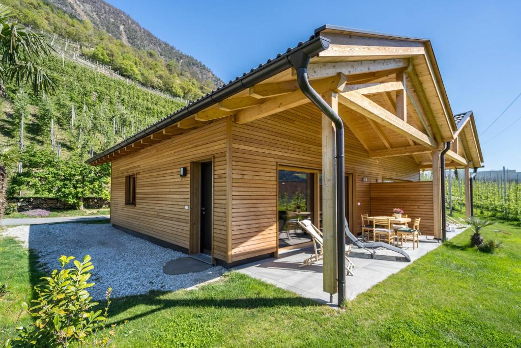 a small wooden cabin with a patio in the grass at Pixnerhof Chalet Bonita in Kastelbell-Tschars