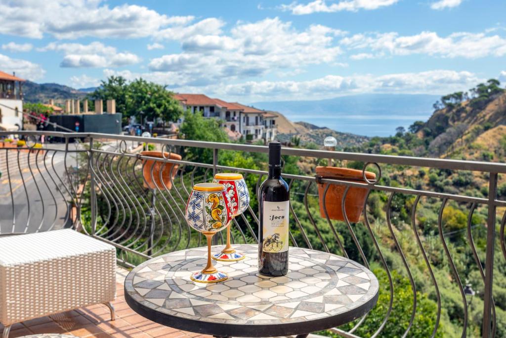 a bottle of wine and two glasses on a table at Pentefur Suite Savoca in Savoca