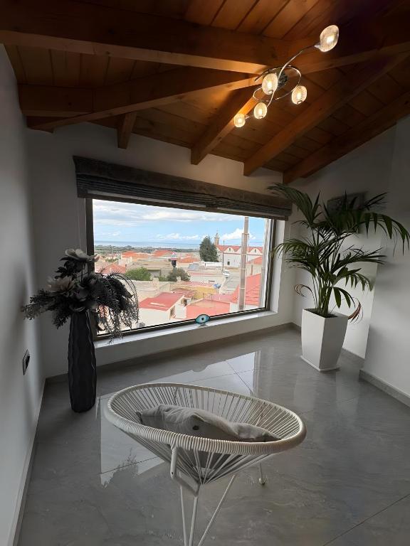 a living room with a table and a large window at Villa Despina in Rhodes Town