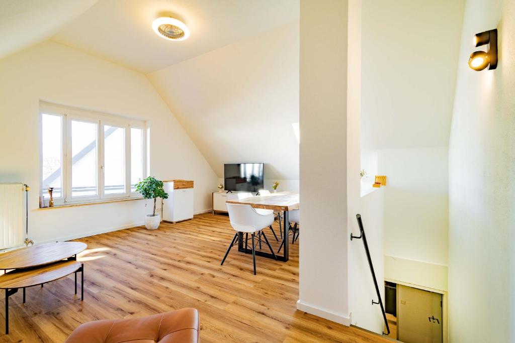 an attic living room with a table and chairs at Kim Fewo 4 in Emmendingen