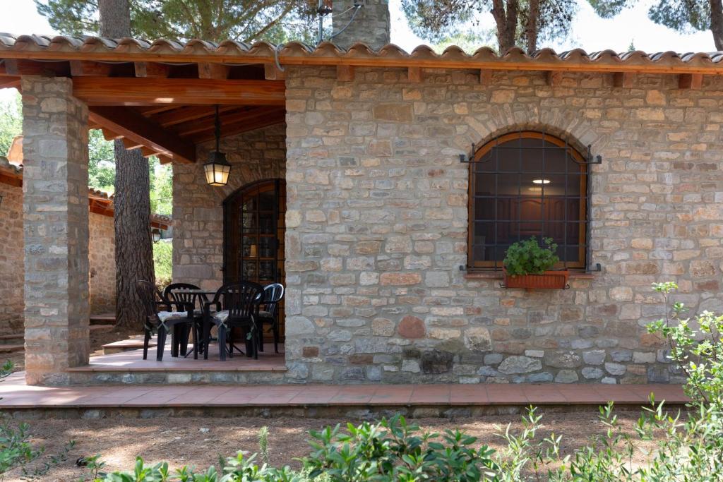 a patio with tables and chairs on a stone wall at Ca la Irene II in Begur