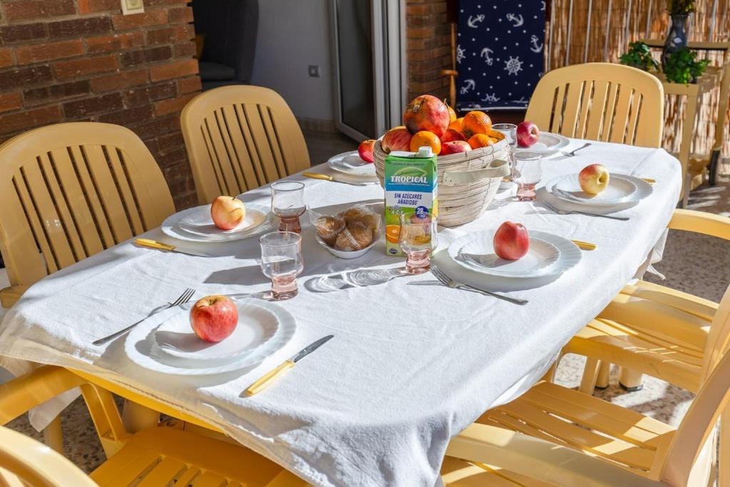 a table with plates of apples and a basket of fruit at Fidalsa Bay View Romance in Guardamar del Segura