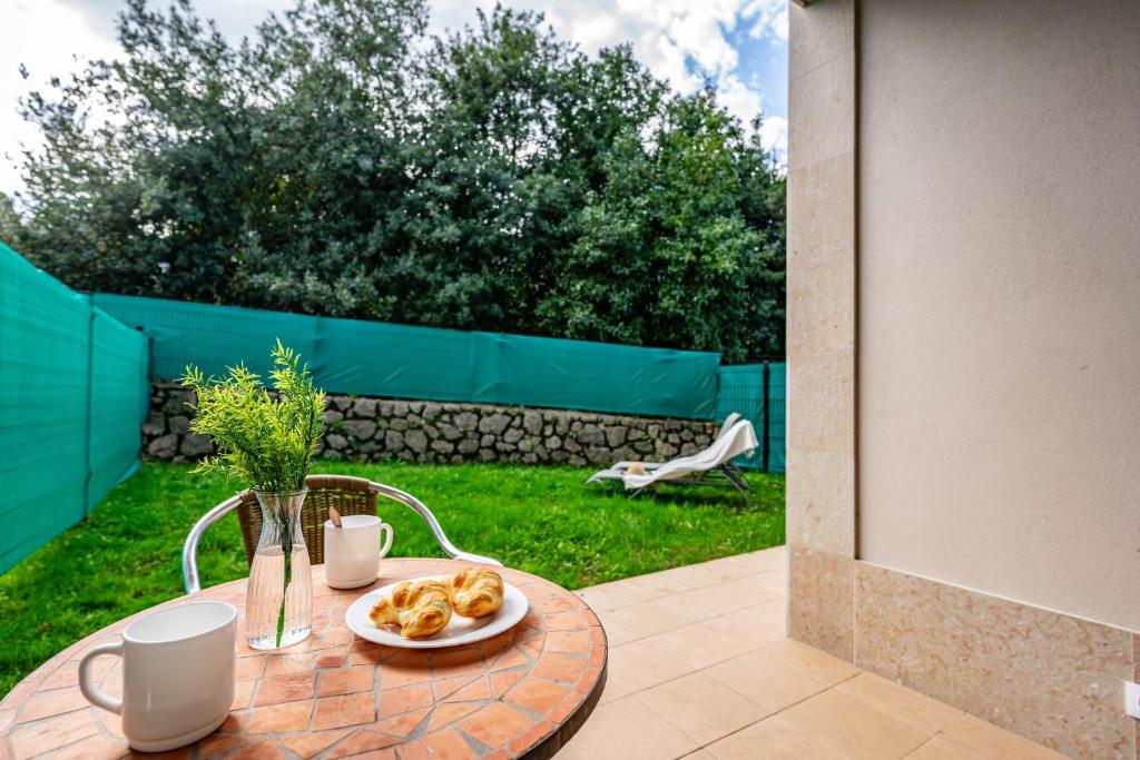 a table with a plate of pastries on top of it at 2 Jardin 1 - Toró in Llanes