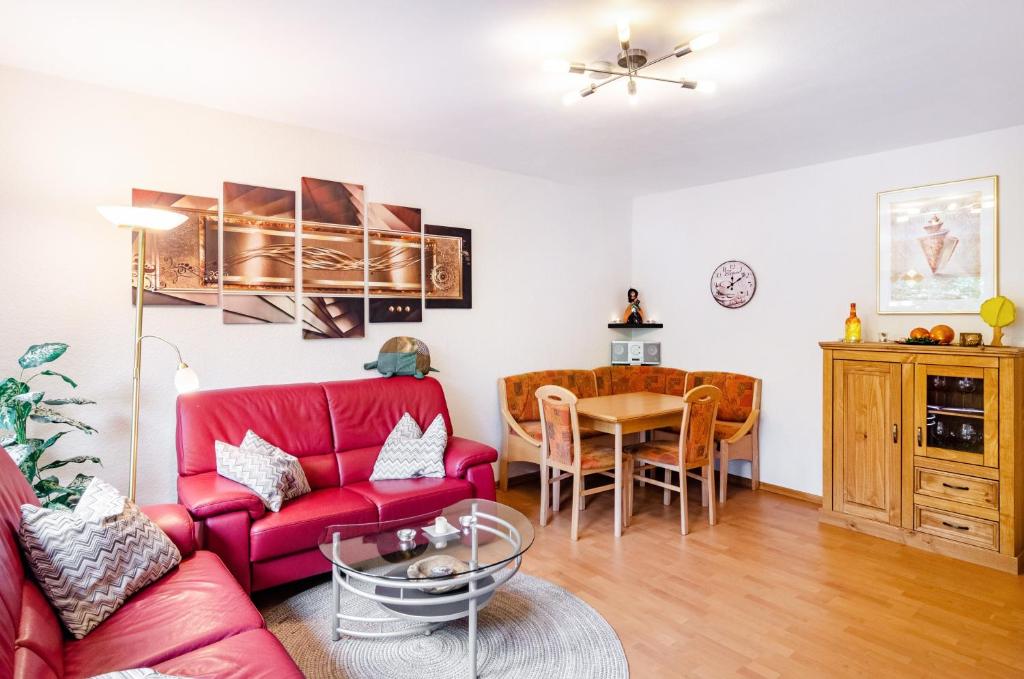 a living room with a red couch and a table at Ferienwohnung Schmälzle in Braunlage
