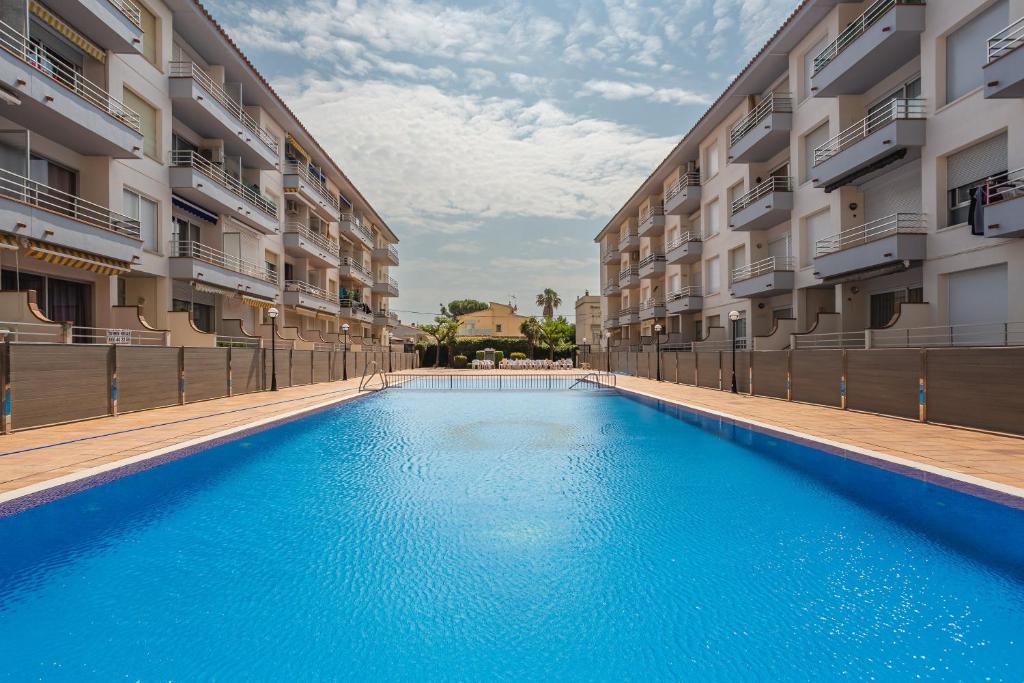 a swimming pool in front of two apartment buildings at Omega 7 in L'Estartit
