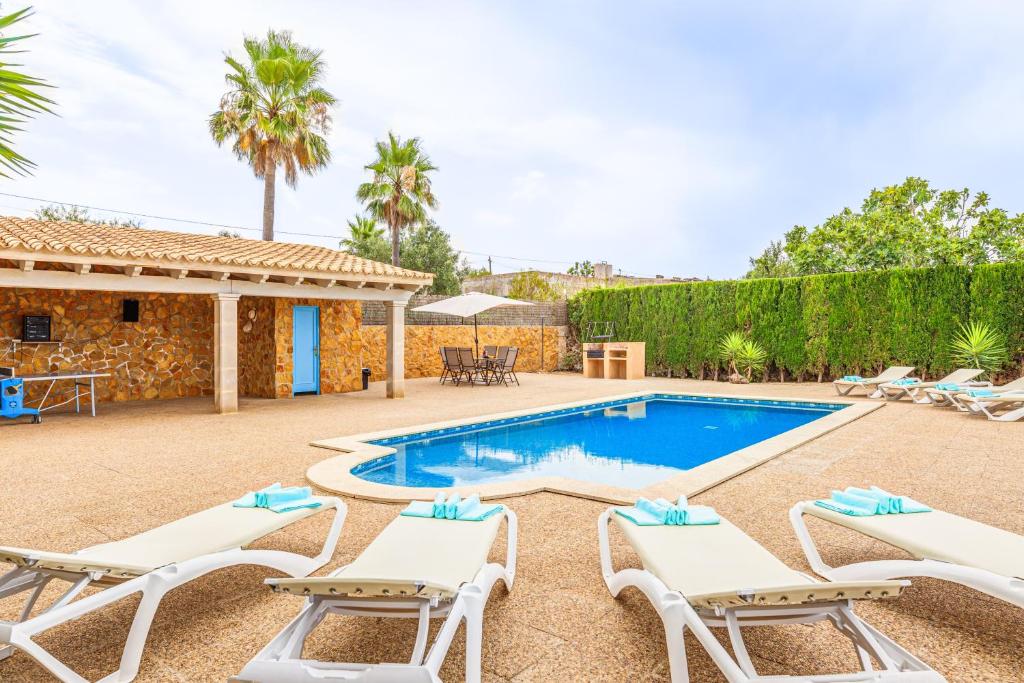 a villa with a swimming pool and lounge chairs at Sa Tanca in Pòrtol