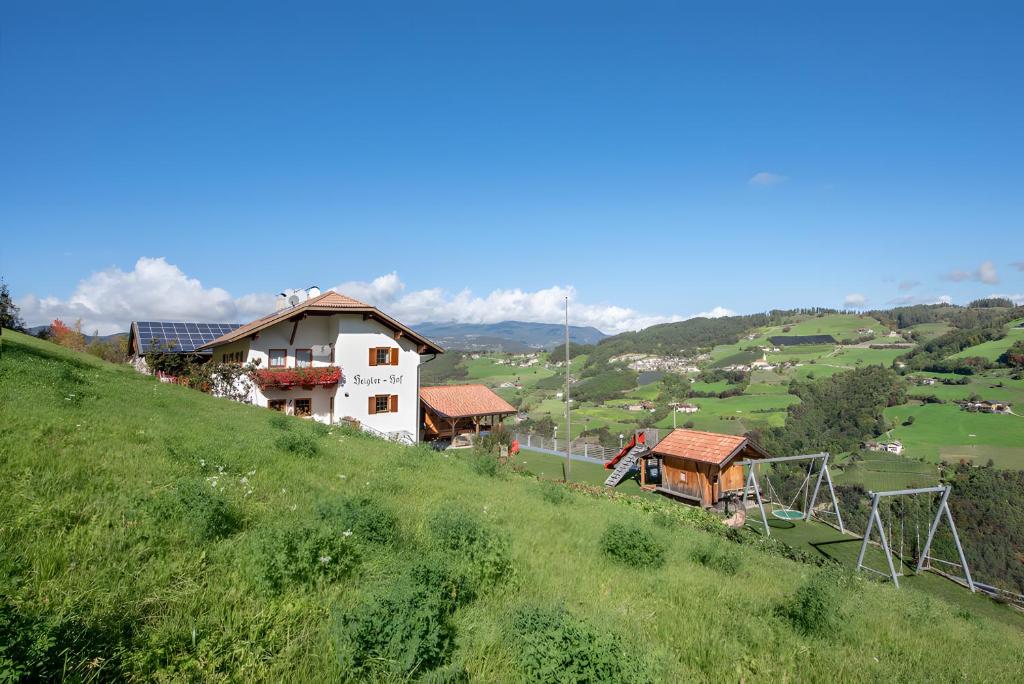 a house on top of a hill with a playground at Wohnung Rosengarten Heigler Hof in Collepietra