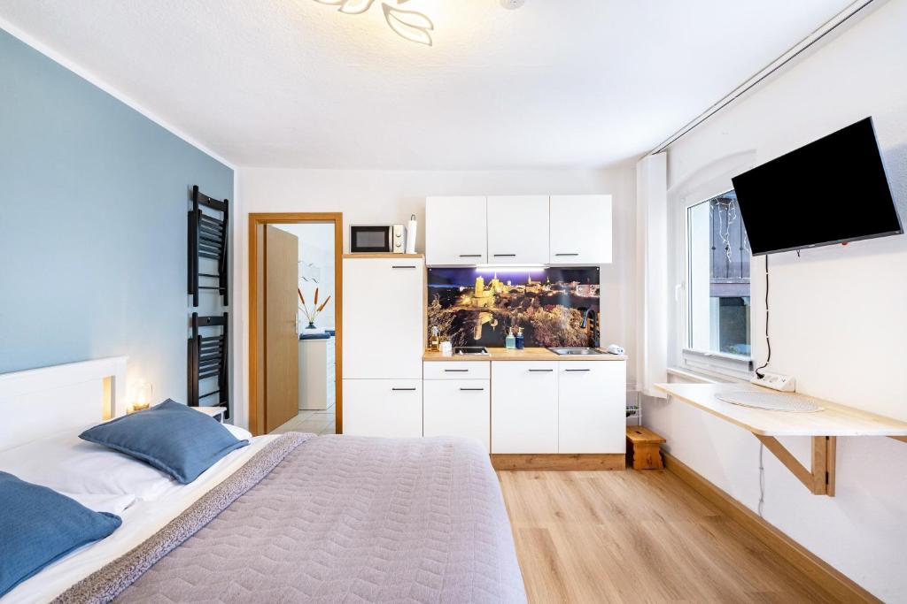 a white bedroom with a bed and a window at Ferienwohnung Steinstübchen in Bautzen