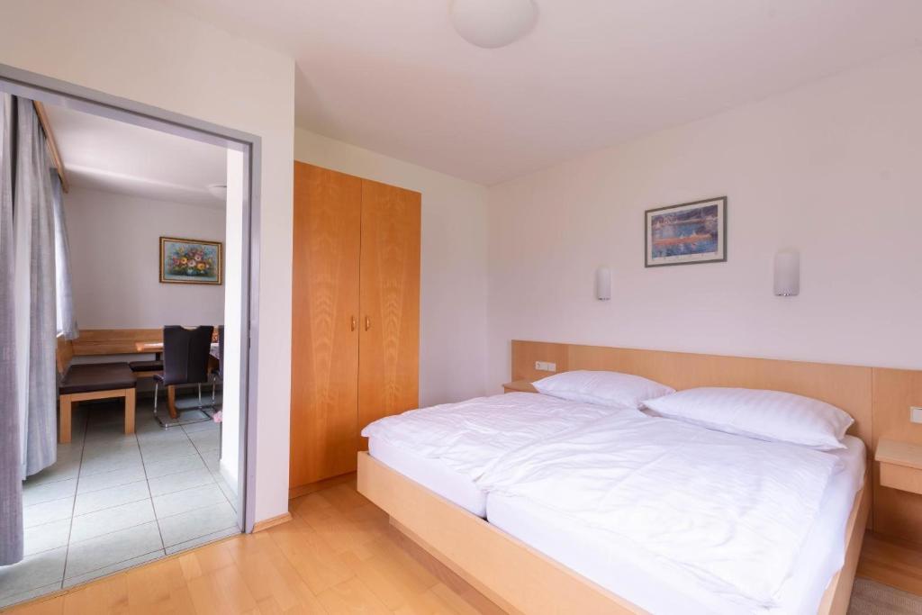 a bedroom with a white bed and a desk at Appartment Isabelle in Lake Pressegg